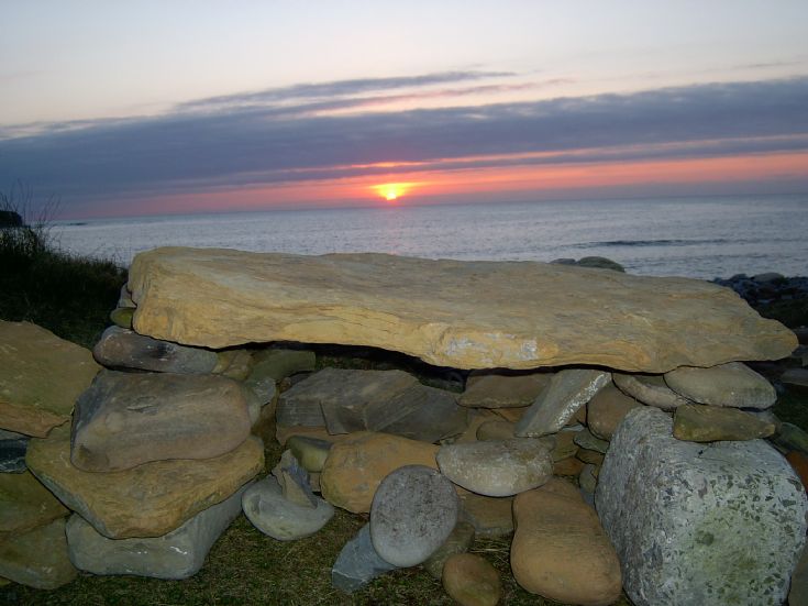 Sunset over cairn at Skaill